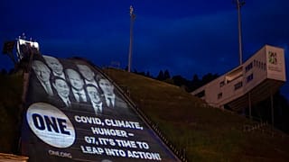 Projection des visages des sept chefs de gouvernement accompagnés du message : "Covid, Climat, faim - G7, il est temps de passer à l'action !", le 25 juin 2022.