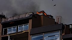 Des oiseaux survolent un immeuble résidentiel après des explosions, à Kyiv, en Ukraine, dimanche 26 juin 2022. 