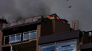Des oiseaux survolent un immeuble résidentiel après des explosions, à Kyiv, en Ukraine, dimanche 26 juin 2022.
