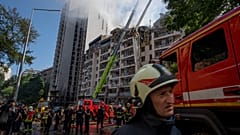 Спасатели разбирают завалы в доме, пострадавшем от ракетного удара по Киеву 26 июня 2022