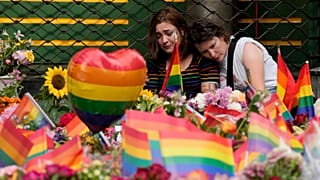 People comfort each other at the scene of a shooting in central Oslo, 25 June 2022