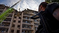 Katasztrófavédelmi szakemberek takarítják el a romokat a 2022. június 26-i kijevi rakéta támadás után