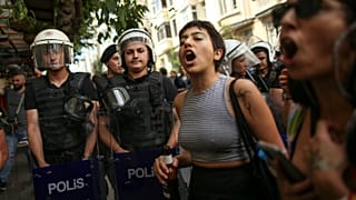 People shout slogans next to Turkish police officers during the LGBTQ Pride March in Istanbul, Turkey, Sunday, June 26, 2022.