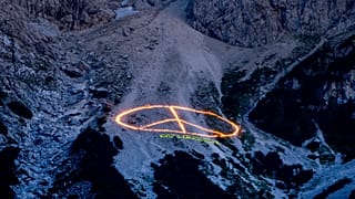 A Greenpeace üzenete a világ vezetőinek, égő fáklyák az Alpokban.