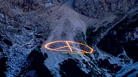 A Greenpeace üzenete a világ vezetőinek, égő fáklyák az Alpokban.