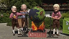 Disfrazados con cabezas gigantes, un grupo de activistas protesta contra los líderes del G7 simulando asar el planeta Tierra