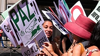 "La paix, du pain pas des bombes" peut on lire sur ces pancartes, lors de la manifestation anti-Otan à Madrid, le 26 juin.