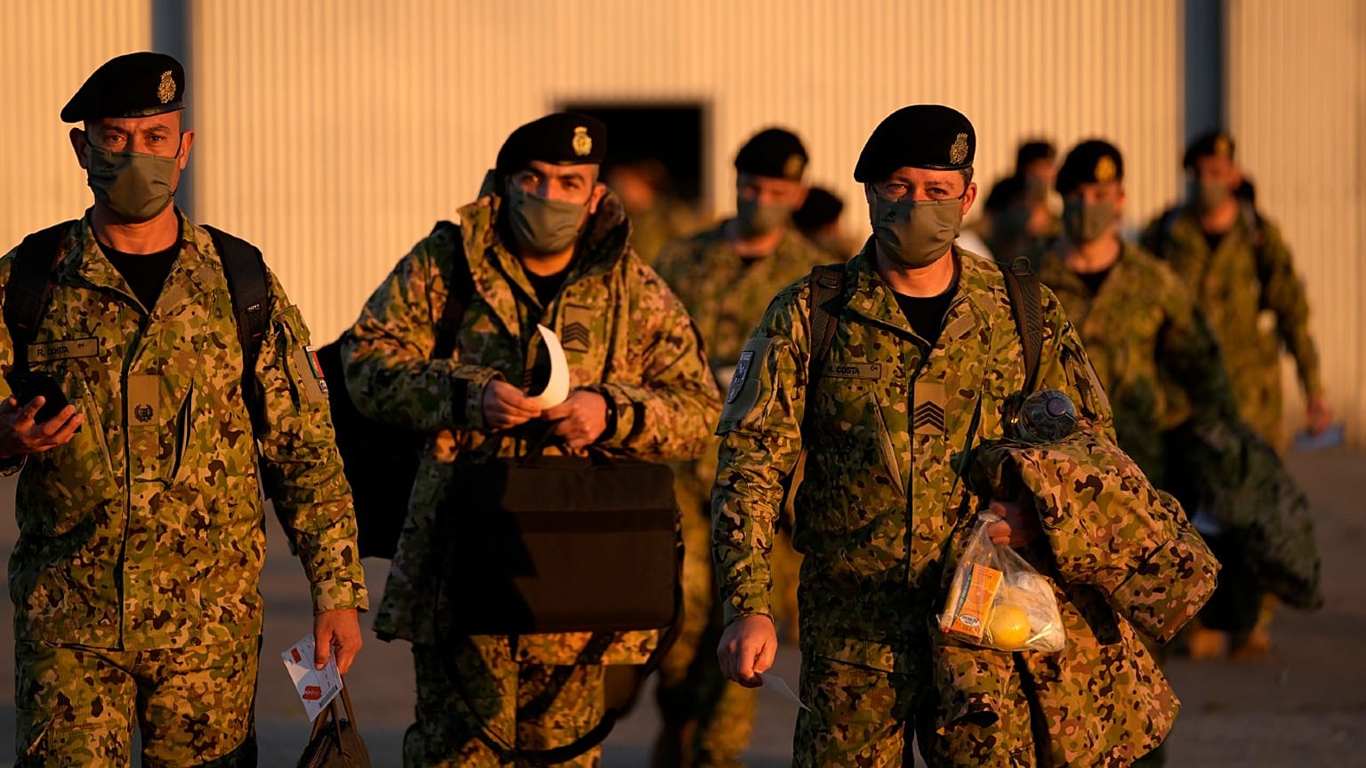Soldiers walk to board an airplane after a farewell ceremony for departing troops, at the military airport in Lisbon, Friday, April 15, 2022