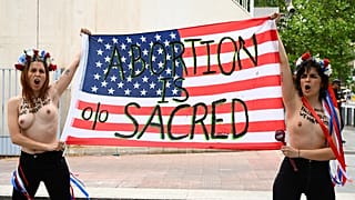 Активистки Femen держат американский флаг с надписью "Аборт священен"