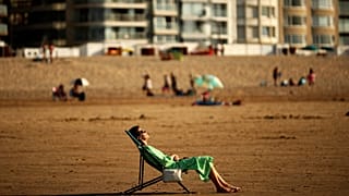 A woman sunbathes during a hot summer day at Zoute beach in Knokke-Heist, north Belgium, Friday, July 31, 2020.