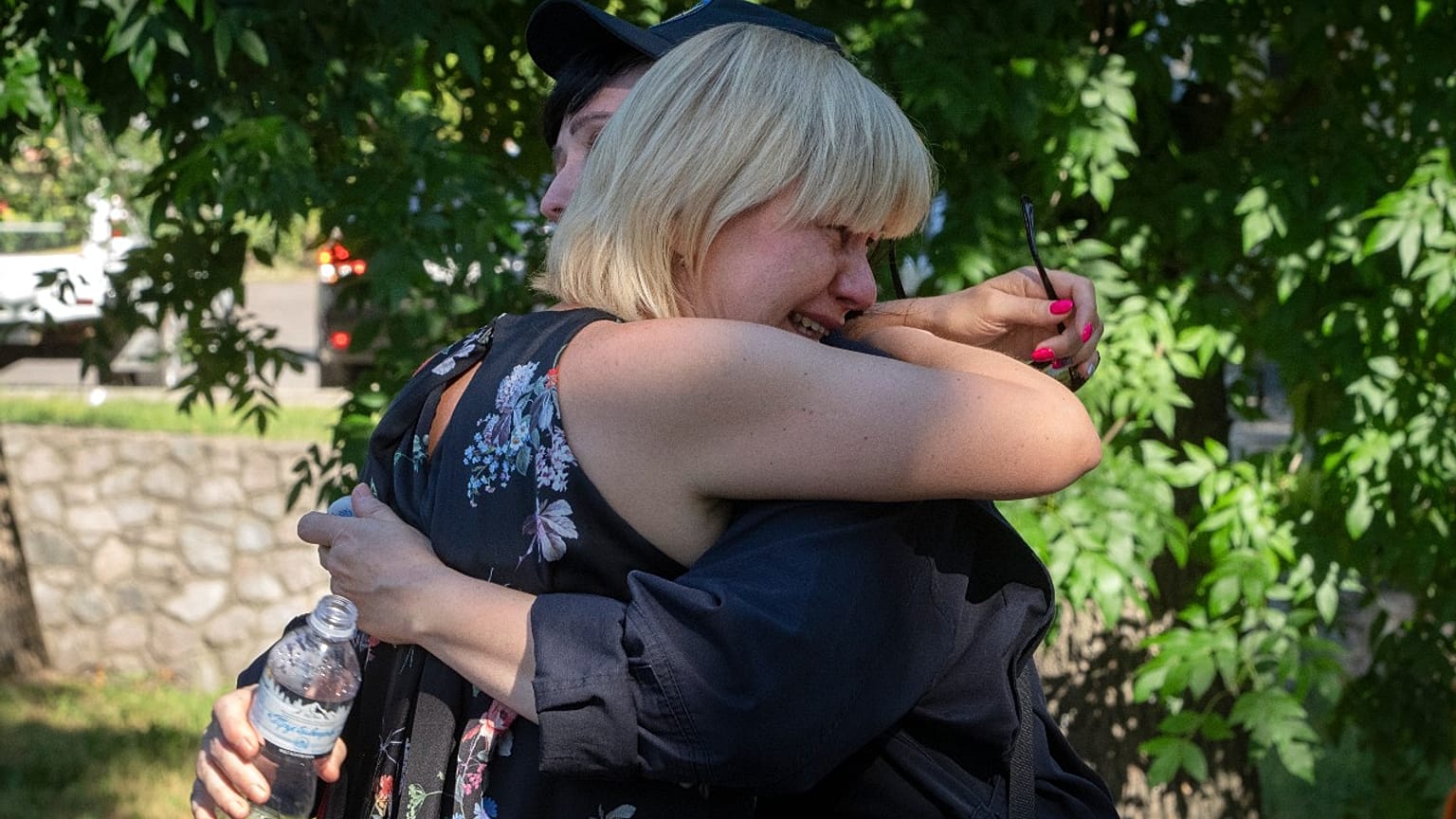 People react at a shopping center burned after a rocket attack in which dozens of people are feared killed and injured, Kremenchuk, Ukraine, Tuesday, June 28, 2022.