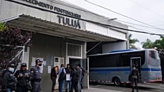 Jail officials and security forces gather outside a jail that suffered a deadly fire in Tulua.