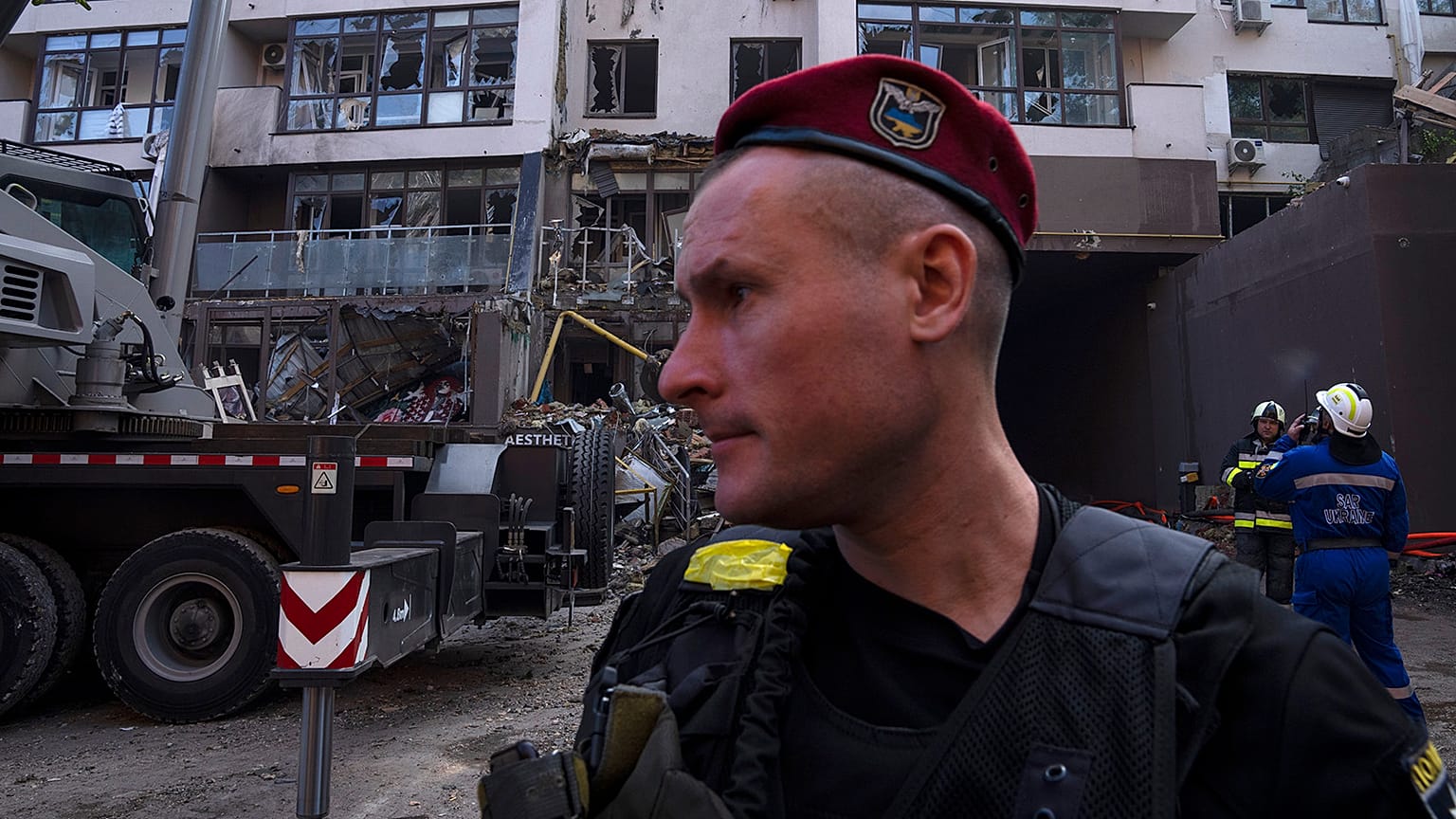 Policemen and firefighters work at the scene of a residential building following explosions, in Kyiv, 26 June 2022
