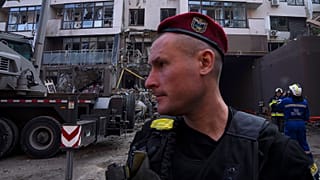 Policemen and firefighters work at the scene of a residential building following explosions, in Kyiv, 26 June 2022