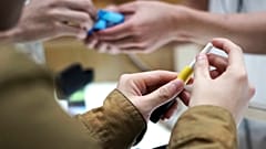 صورة أرشيفية لزوّار يجربون جهازاً لتدخين التبغ المسخّن في متجر "أي كيو كيو إس" بالعاصمة اليابانية، طوكيو، 22 أكتوبر 2018.