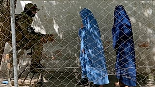 مقاتل من طالبان يحرس مدخل النساء إلى مكتب الجوازات الحكومي في كابول - أفغانستان.