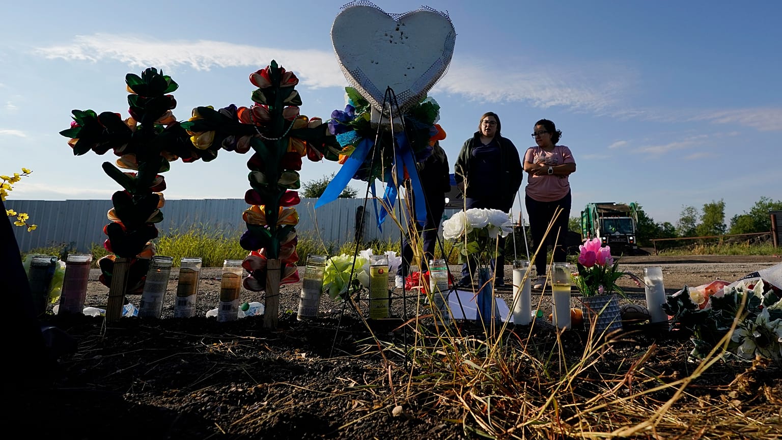 Los dolientes presentan sus respetos en un monumento improvisado en el lugar donde las autoridades encontraron el camión con los migrantes dentro, el 29 de junio de 2022.