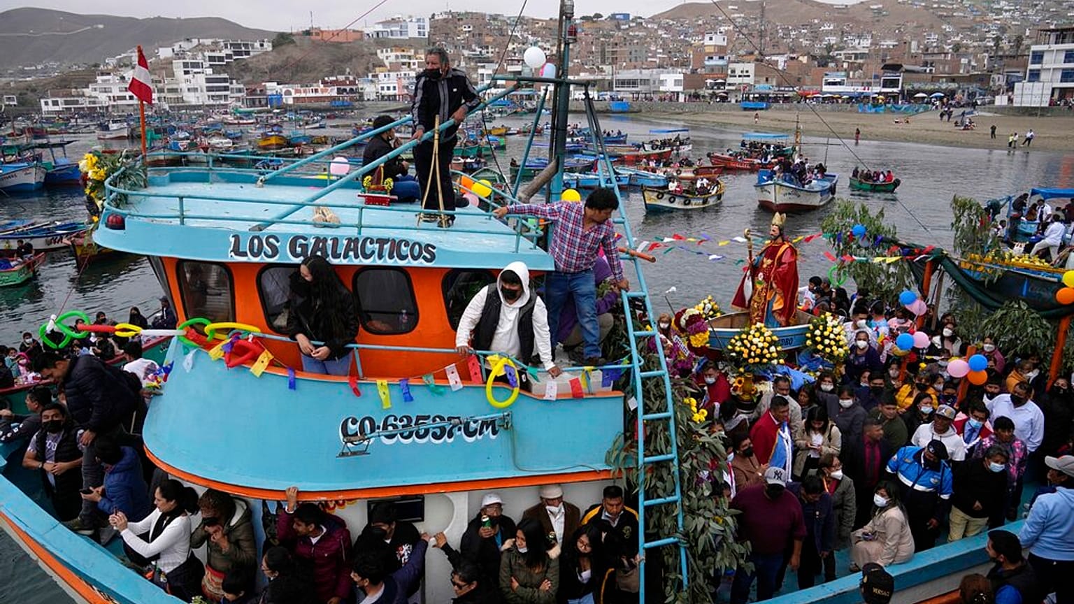 Procesión por tierra y mar en honor de San Pedro, patrón de los pescadores, en el puerto de Pucusana, en Perú.