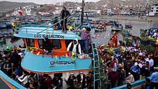 Procesión por tierra y mar en honor de San Pedro, patrón de los pescadores, en el puerto de Pucusana, en Perú.