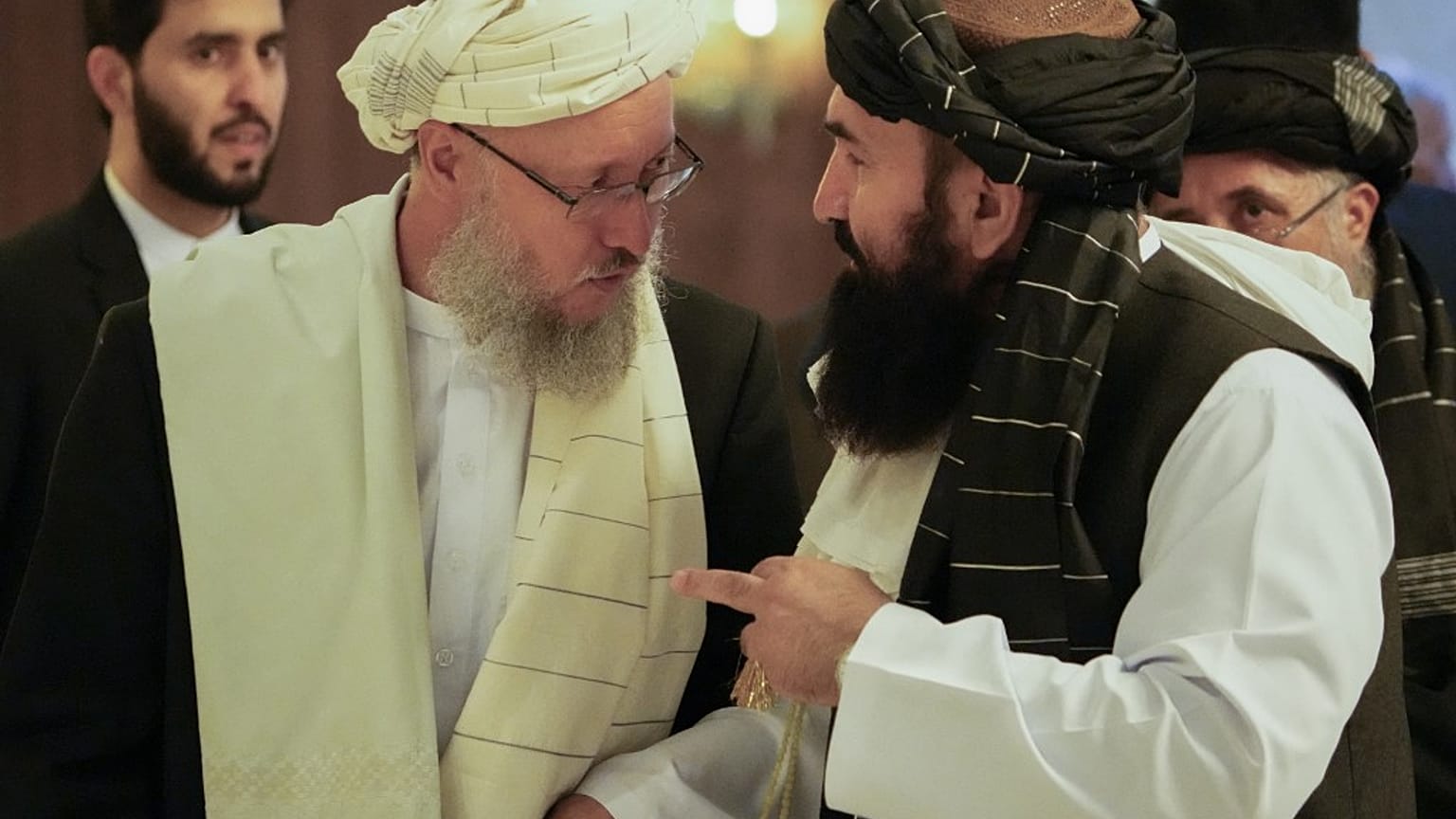 Deputy prime minister Abdul Salam Hanafi (L) speaks with acting Foreign Minister of Afghanistan, Taliban official Amir Khan Muttaqi during an international conference (2021).