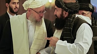 Deputy prime minister Abdul Salam Hanafi (L) speaks with acting Foreign Minister of Afghanistan, Taliban official Amir Khan Muttaqi during an international conference (2021).