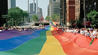 A mile-long rainbow is carried past the United Nations secretariat building during a march to commemorate the 25th anniversary of the stonewall riots Sunday, June 26, 1994