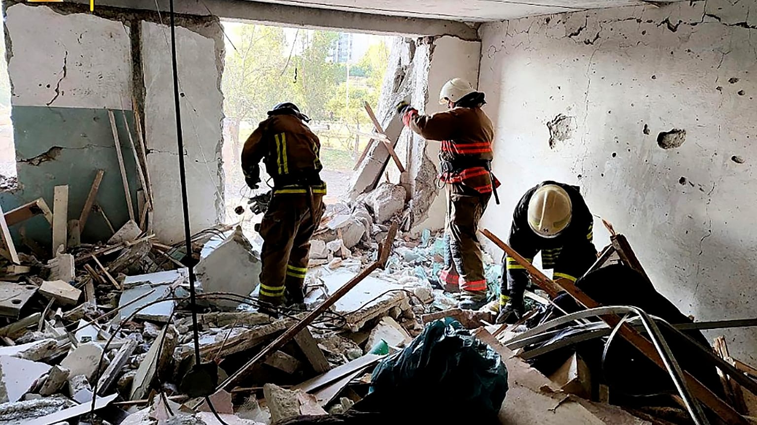 First responders work in a damaged residential building in Odesa, Ukraine, early Friday, July 1, 2022, following Russian missile attacks.