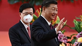 Hong Kong's new Chief Executive John Lee, left, walks with China's President Xi Jinping after a ceremony to inaugurate a new leader and government, Hong Kong, July 1, 2022.