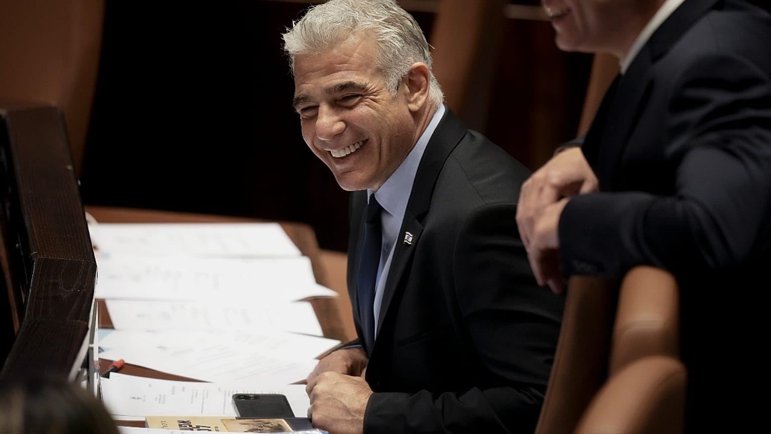 Israeli Foreign Minister Yair Lapid smiles ahead of the vote on a bill to dissolve parliament, at the Knesset, Israel's parliament, in Jerusalem, Thursday, June 30, 2022.