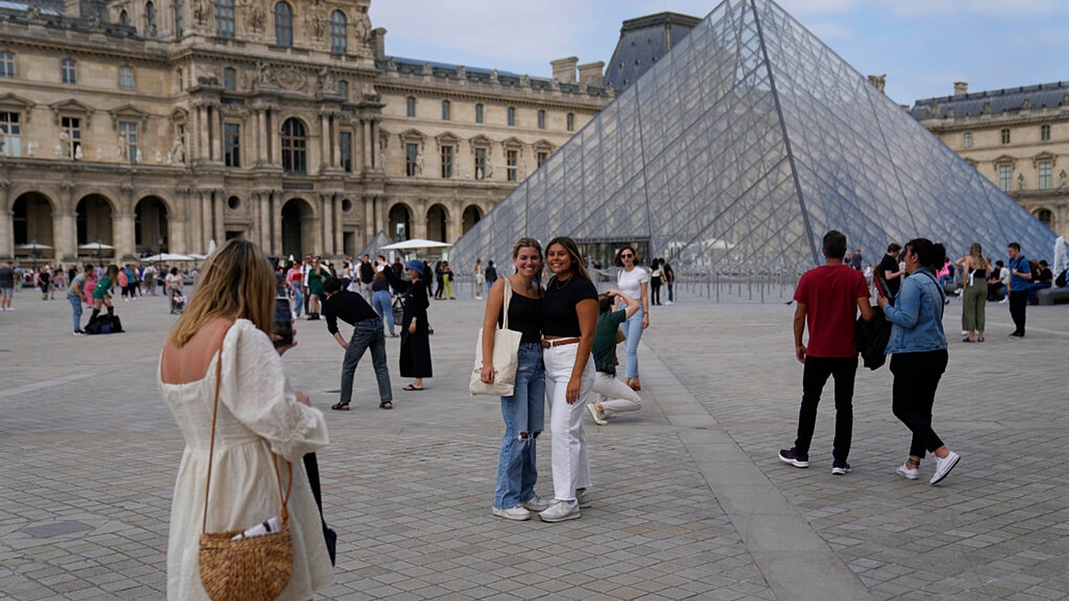 Touristinnen posieren vor dem Louvre im Paris am 20. Juni 2022
