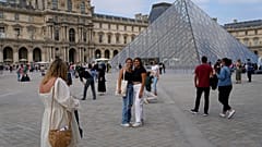Touristinnen posieren vor dem Louvre im Paris am 20. Juni 2022