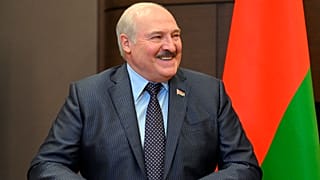Belarusian President Alexander Lukashenko smiles while speaking to Russian President Vladimir Putin during their meeting in Sochi in May 2022