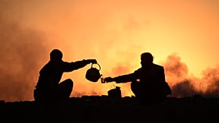 Lavoratori bevono il tè a fine giornata nei sobborghi di Mazar
