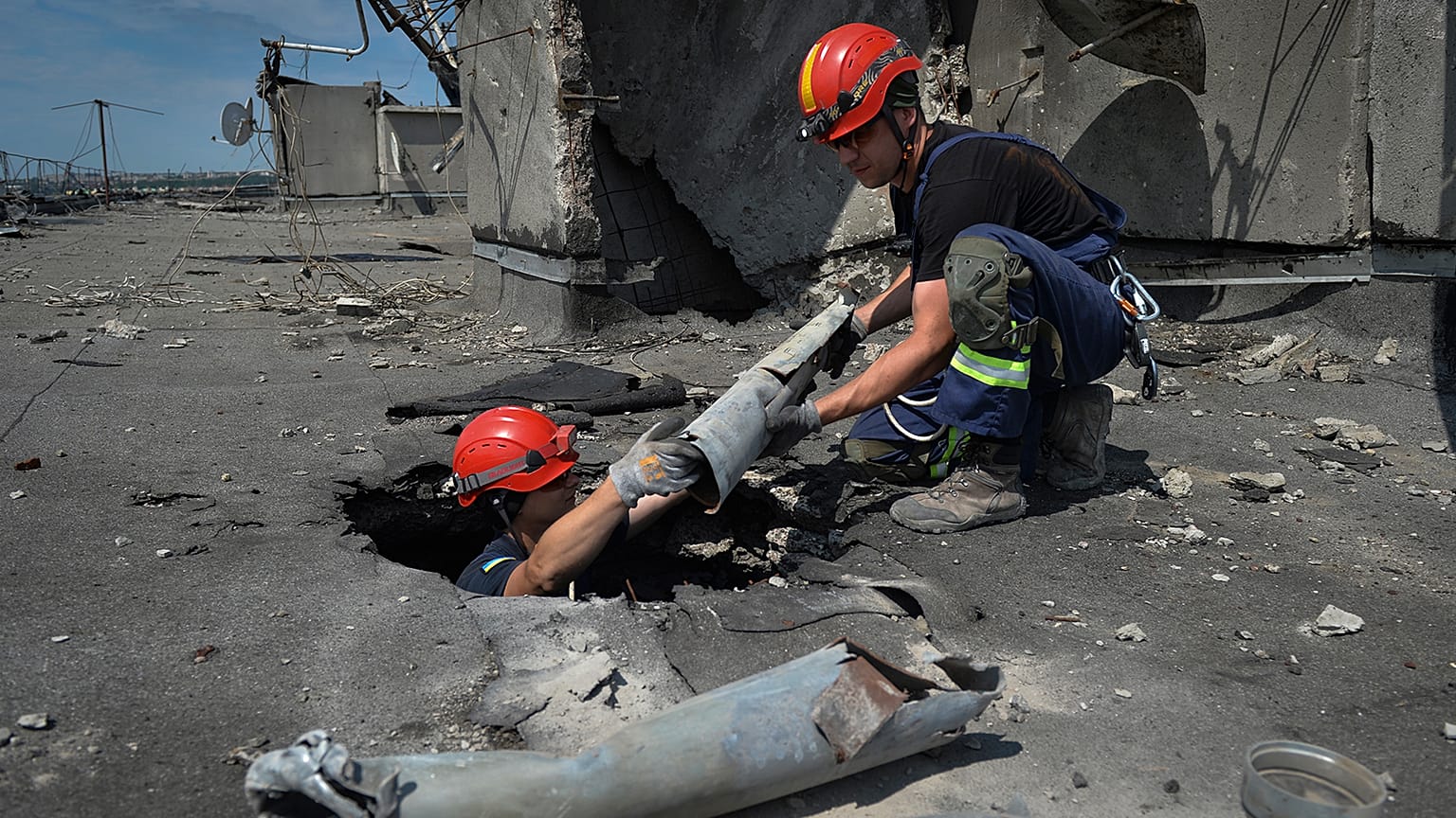Ukrainian rescuers retrieve the remains of Russian shells on the roof of a high-rise damaged by Russian shelling in one of the residential areas of Kharkiv, 30 June 2022