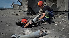 Ukrainian rescuers retrieve the remains of Russian shells on the roof of a high-rise damaged by Russian shelling in one of the residential areas of Kharkiv, 30 June 2022