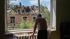 A 81 éves Victor Rosenberg bakhmuti lakos néz ki az ablakán a lerombolt városra