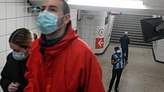 A man wearing a face mask to protect against COVID-19 looks at an information board at train station in Paris, Thursday, June 30, 2022.