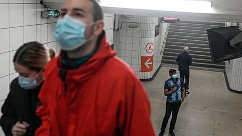 A man wearing a face mask to protect against COVID-19 looks at an information board at train station in Paris, Thursday, June 30, 2022.