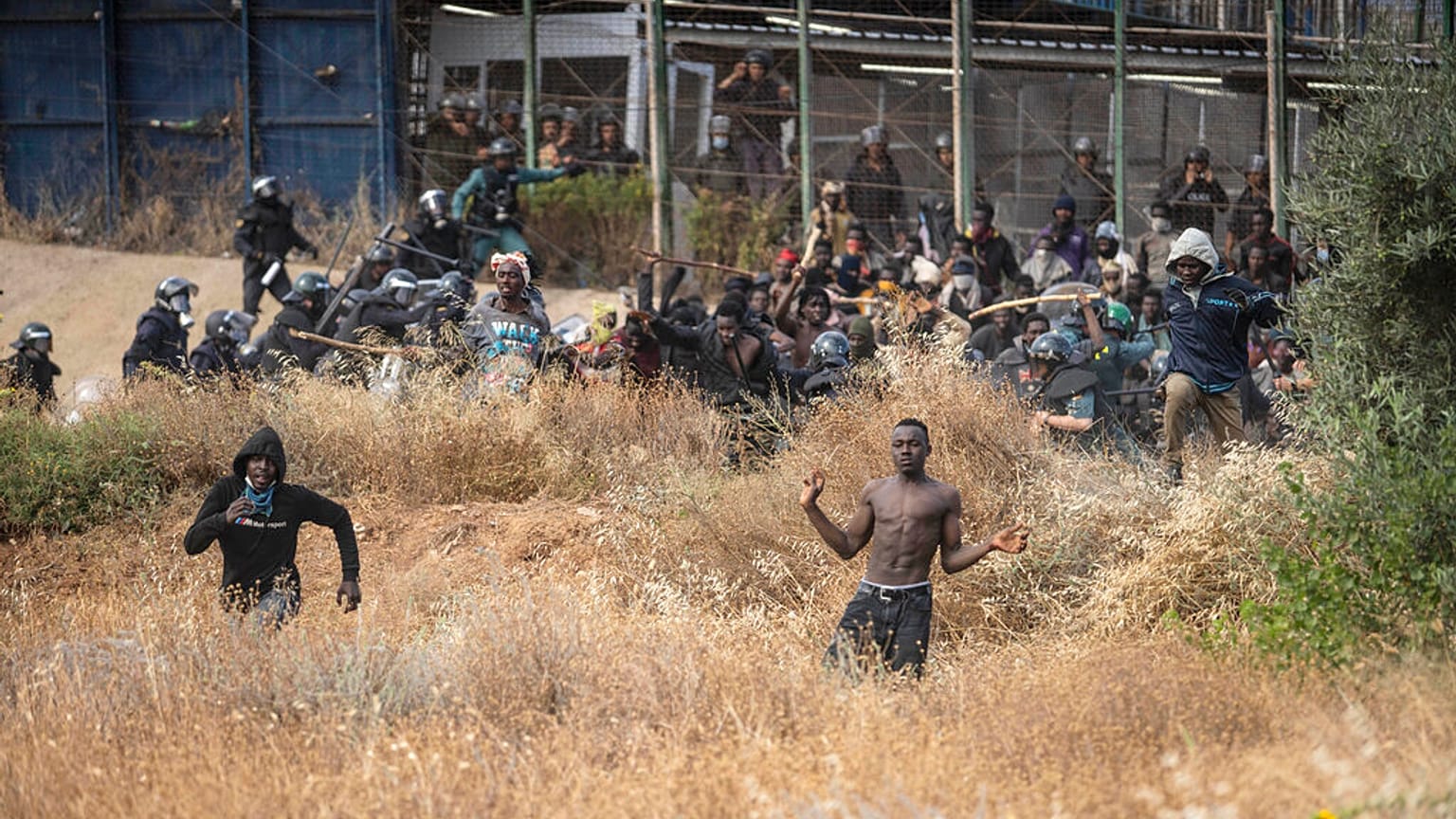 Des migrants traversant le grillage de l'enclave espagnole de Melilla, le 24 juin 2022