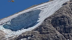A rescue helicopter hoovers over the Punta Rocca glacier near Canazei, in the Italian Alps in northern Italy, July 4, 2022, a day after a huge chunk of the glacier broke loose