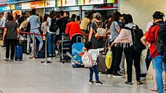 Passengers queue in Lisbon international airport in 2018