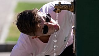 A tourist drinks water from a public fountain at the Sforzesco Castle, in Milan, Italy, Saturday, June 25, 2022.
