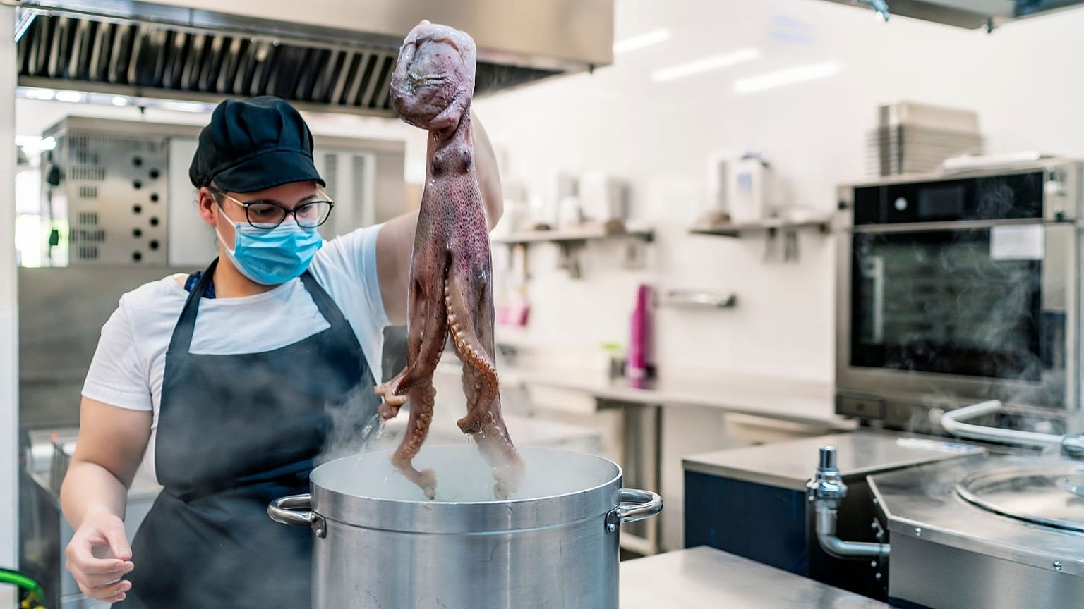A hotel worker cooking in the kitchen.