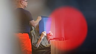 المتهم يخفي وجهه أمام وسائل الإعلام