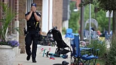 A Lake County police officer walks down Central Avenue in downtown Highland Park, a Chicago suburb, after a mass shooting at the 4 July parade