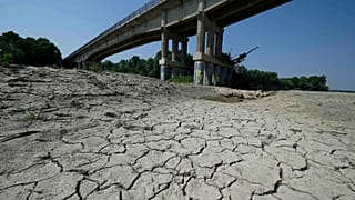 Dry cracked land is visible under a bridge in Boretto on the bed of the Po river, 15 June 2022