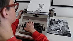 Artist James Cook using a typewriter to create a portrait of a dog 
