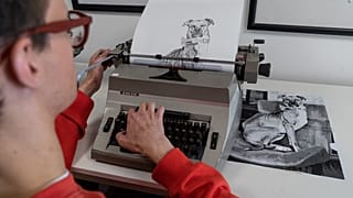 Artist James Cook using a typewriter to create a portrait of a dog