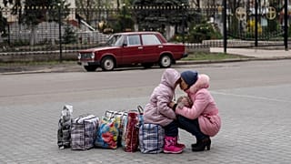 Une mère et sa fille attendent un bus pour fuir la ville de Sloviansk, dans la région de Donetsk, 16 avril 2022.