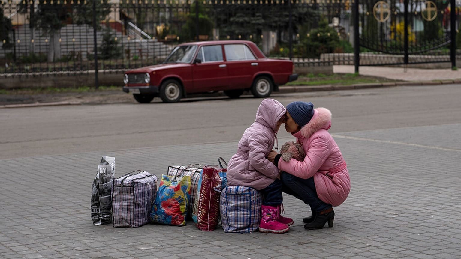 Mãe abraça a filha enquanto esperam pelo autocarro que as levará da cidade de Sloviansk, em Donetsk, Ucrânia